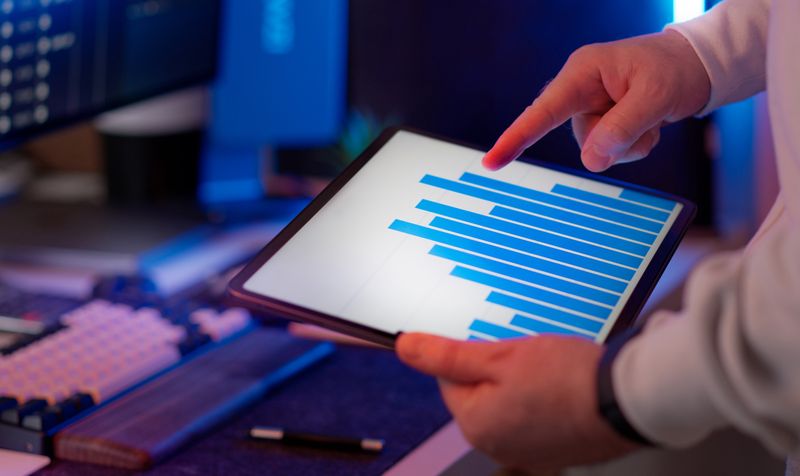 Business professional analyzing bar chart on tablet in office setting